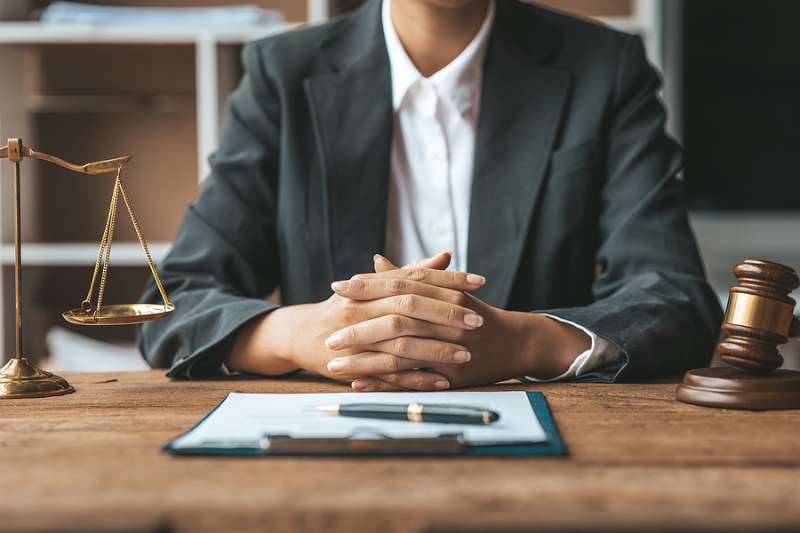 Woamn lawyer at desk with clipoard on desk