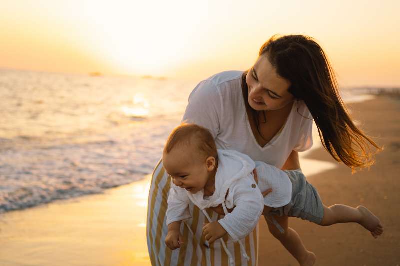 mother and baby at beach image