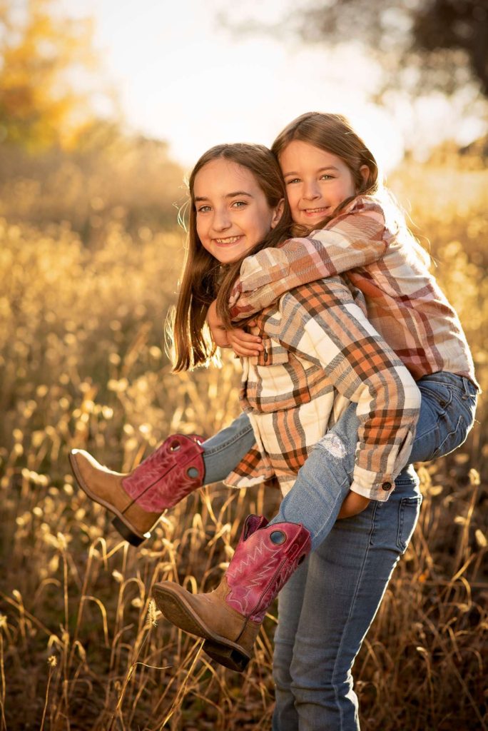 Rachel's daughters. One daughter piggyback riding the other on About Us page