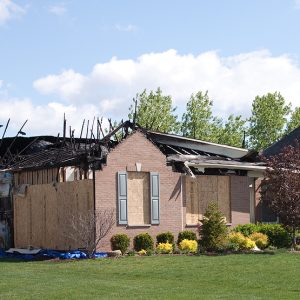 A close up shot of a severely fire damaged residential home in a residential community, Estate Planning for Fire-Prone Areas